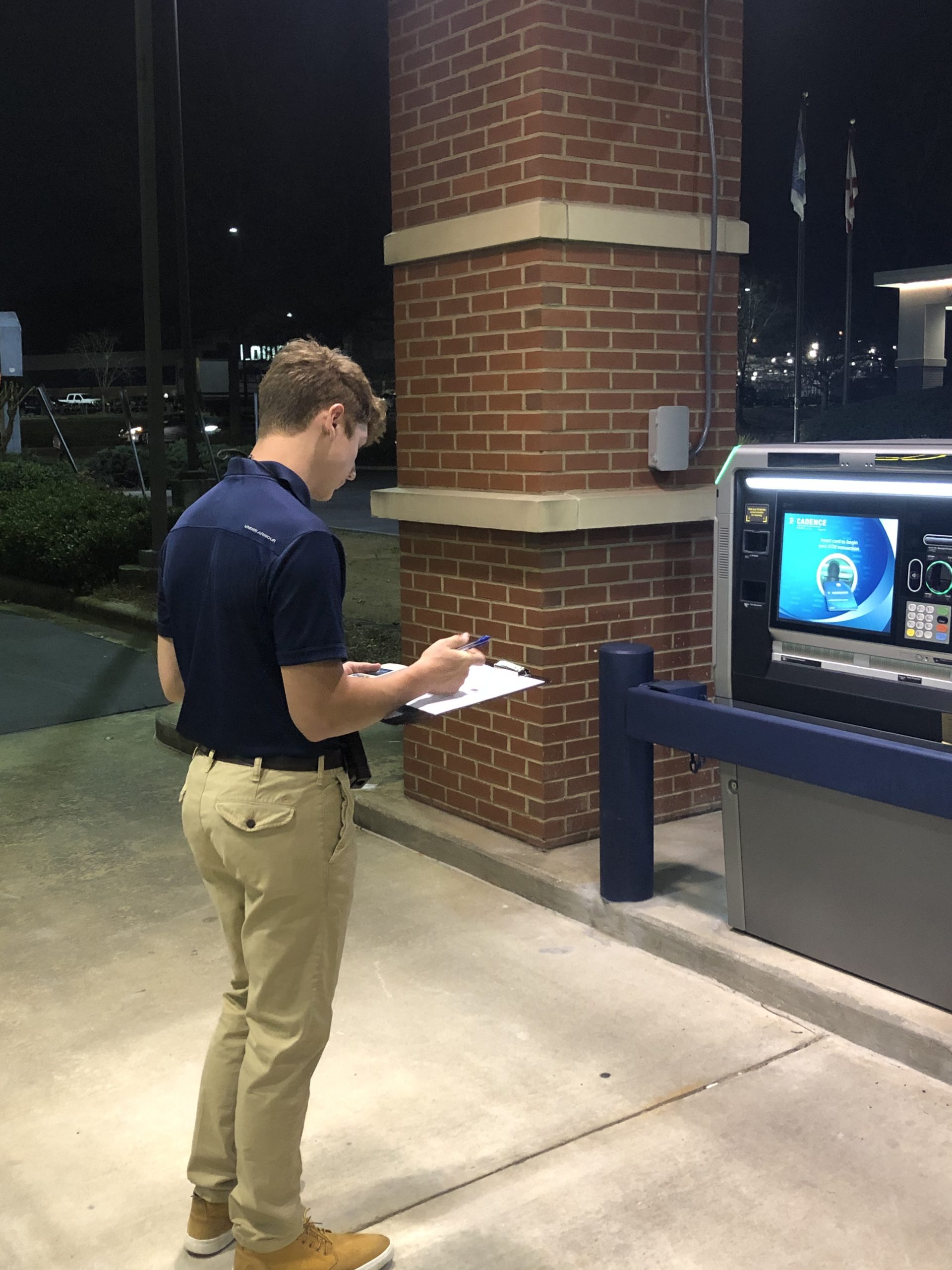 Customer entering a PIN at an ATM keypad